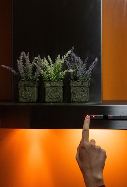 A close-up of a smart lighting control panel on a wall, with touch controls illuminated. In the background, a subtle glow of smart lights in a hallway.