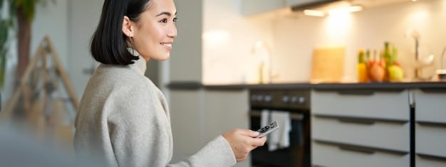 A person using a smartphone to control a smart oven from their living room, demonstrating remote connectivity and convenience, with an elegant, modern home interior in the background.
