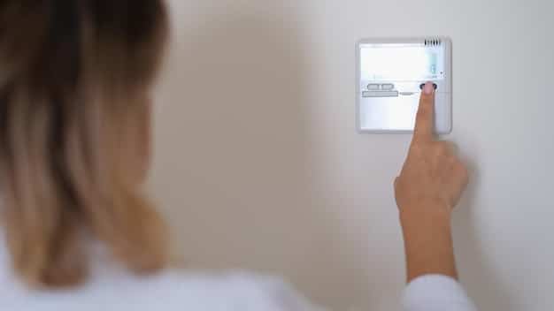 A close-up of a smart thermostat on a wall, with large, clear numbers and a hand reaching to adjust it, signifying easy climate control in an accessible home.